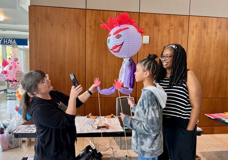 The instructor shows workshoppers how to pose their Lantern Puppets 