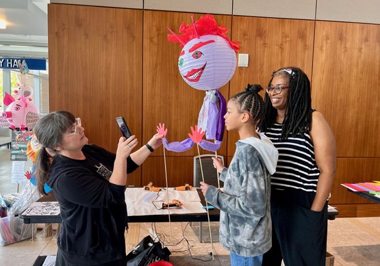 The instructor shows workshoppers how to pose their Lantern Puppets 