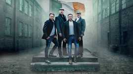 Members of the High KIngs with the Irish flag behind them