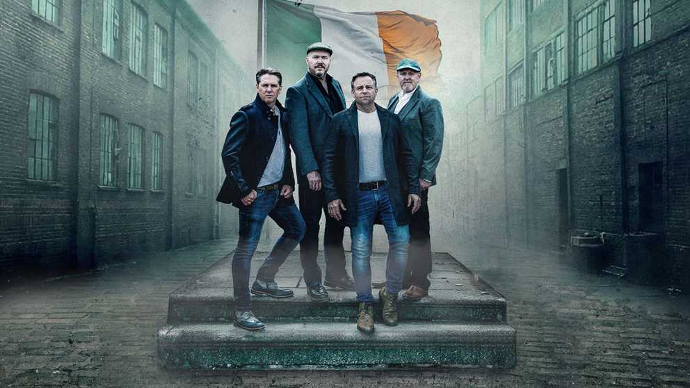 Members of the High KIngs with the Irish flag behind them