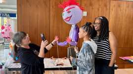 The instructor shows workshoppers how to pose their Lantern Puppets 