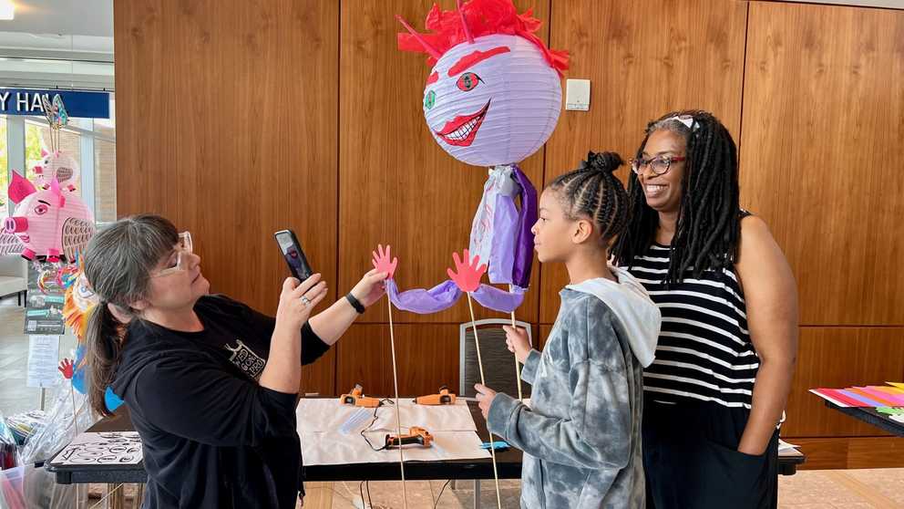 The instructor shows workshoppers how to pose their Lantern Puppets 