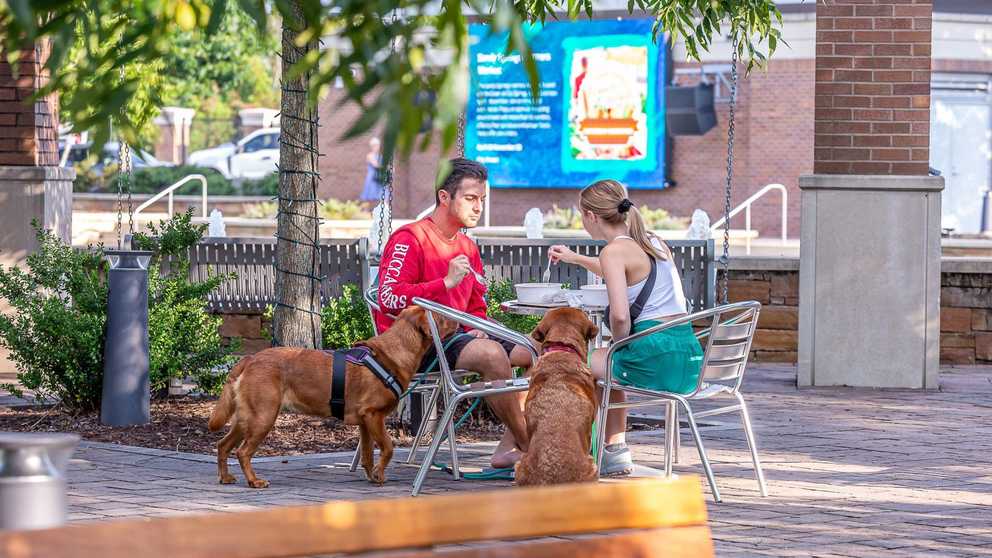 Man and woman eating in the plaza