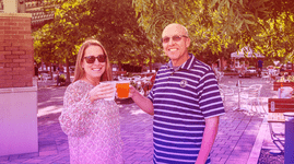 Two people cheers their drinks at Sundown Social 