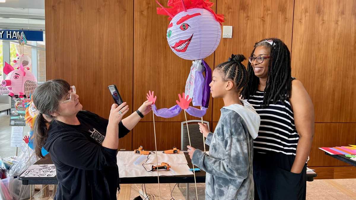 The instructor shows workshoppers how to pose their Lantern Puppets 